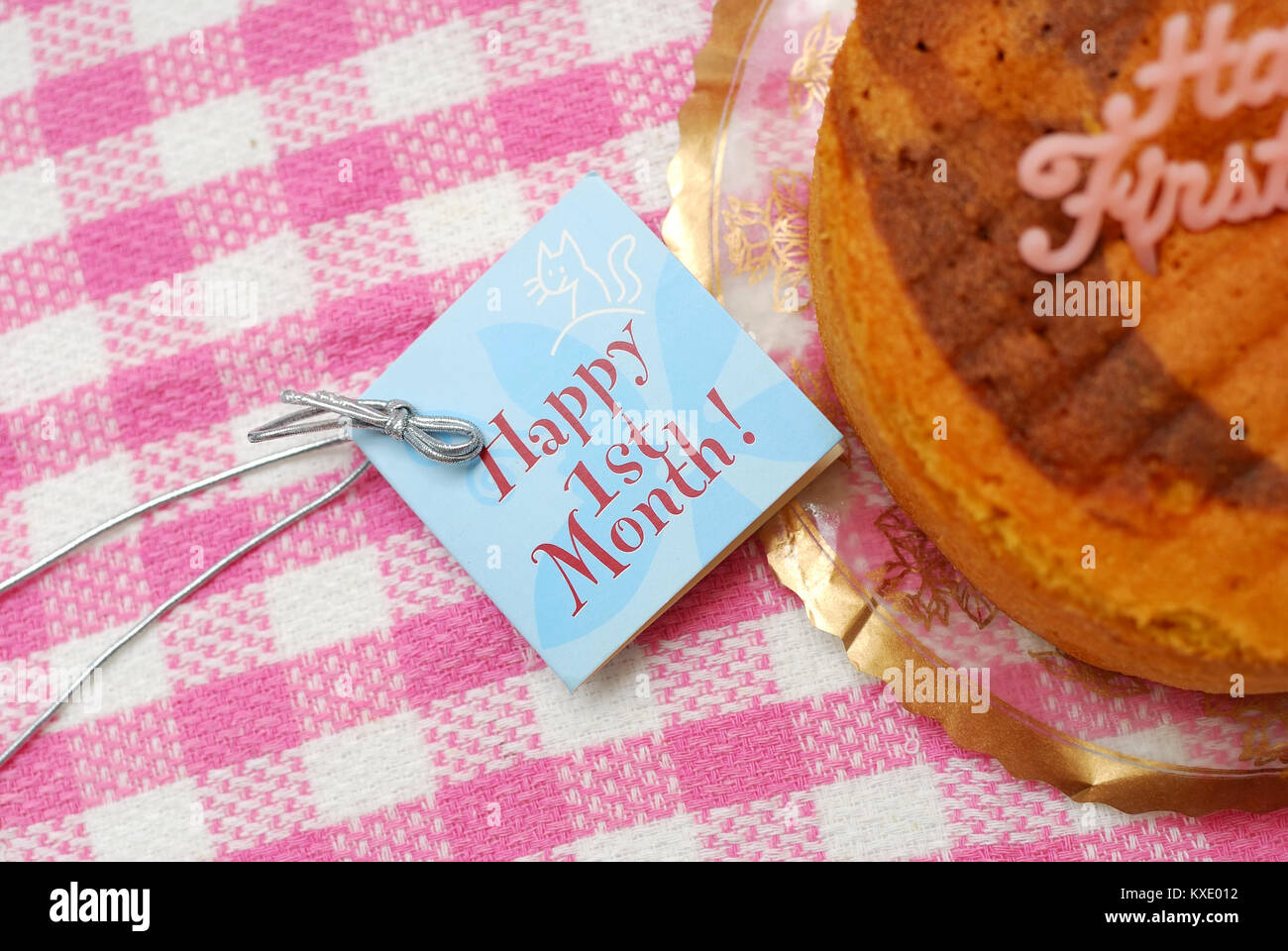 Glückwunsch Karte neben leckeren Kuchen zu feiern Jubiläum des ersten Monats ein Baby. Copyspace zur Verfügung. Geeignet für Feiern, Feste, Stockfoto