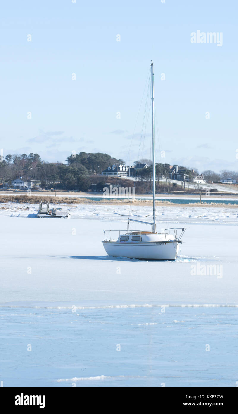 Warten auf Frühling. Ein Segelboot in runden Teich gefroren und Einlass in Harwich, Massachusetts, auf Cape Cod, USA Stockfoto