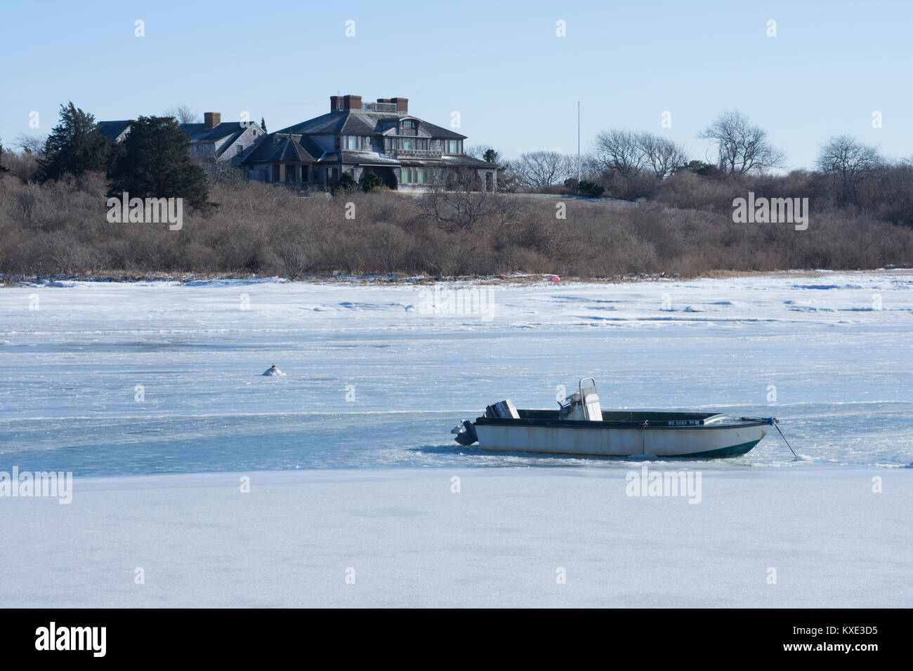 Ein Sommerhaus und ein Boot mooried in der Mitchell River im Winter. Chatham, Massachusetts, auf Cape Cod, USA Stockfoto