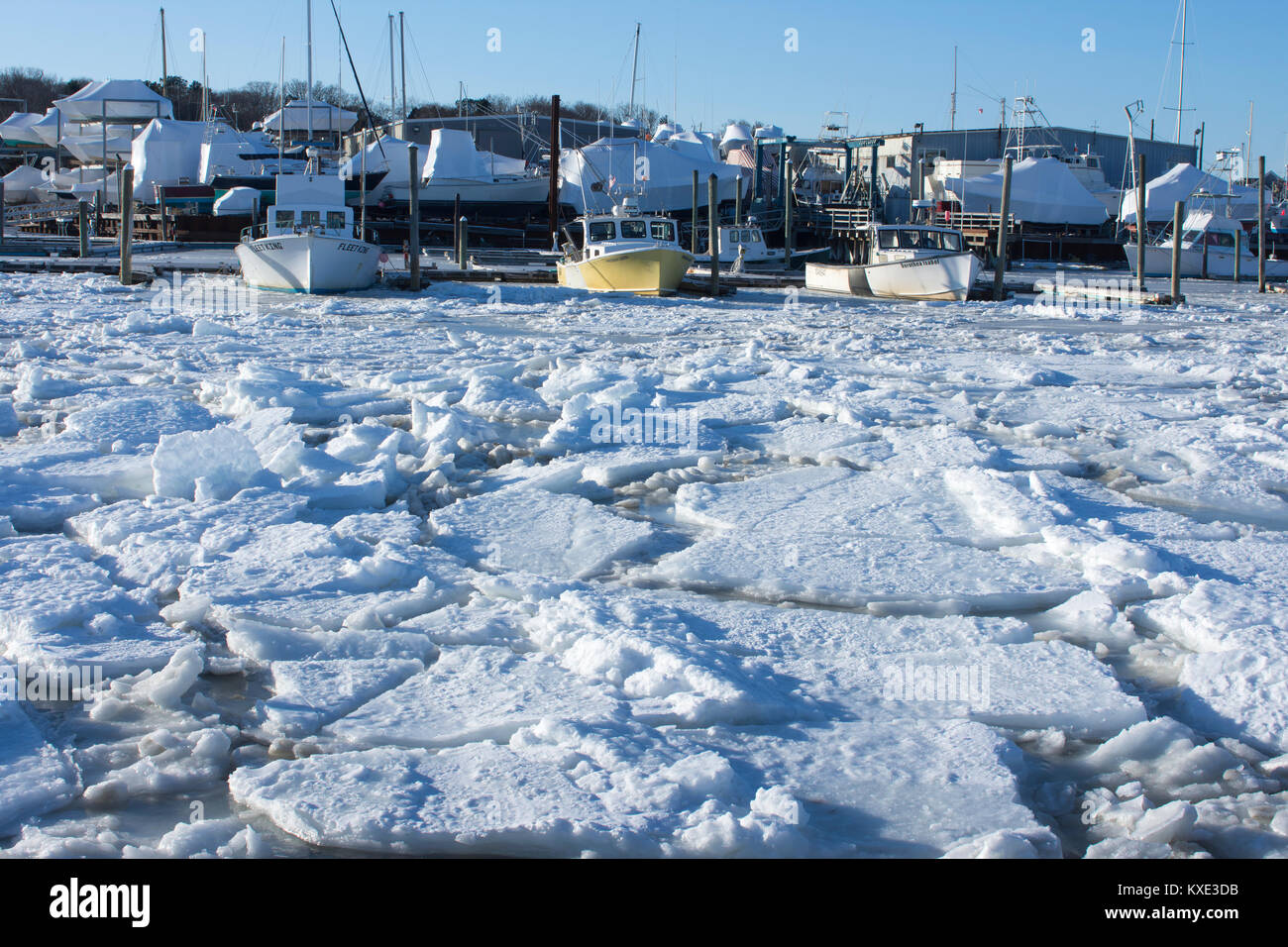 Angedockt und Boote an einem gefrorenen Sesuit Harbor, Dennis, Massachusetts, Cape Cod, USA an einem kalten Wintertag gespeichert Stockfoto