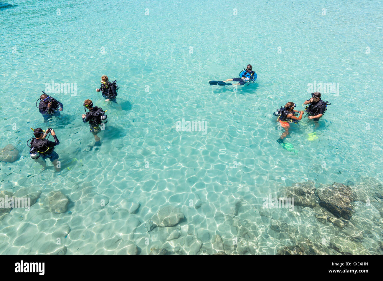 Eine Gruppe von Studenten Tauchen haben eine Lektion im flachen kristallklarem Wasser von einer tropischen Insel. Stockfoto