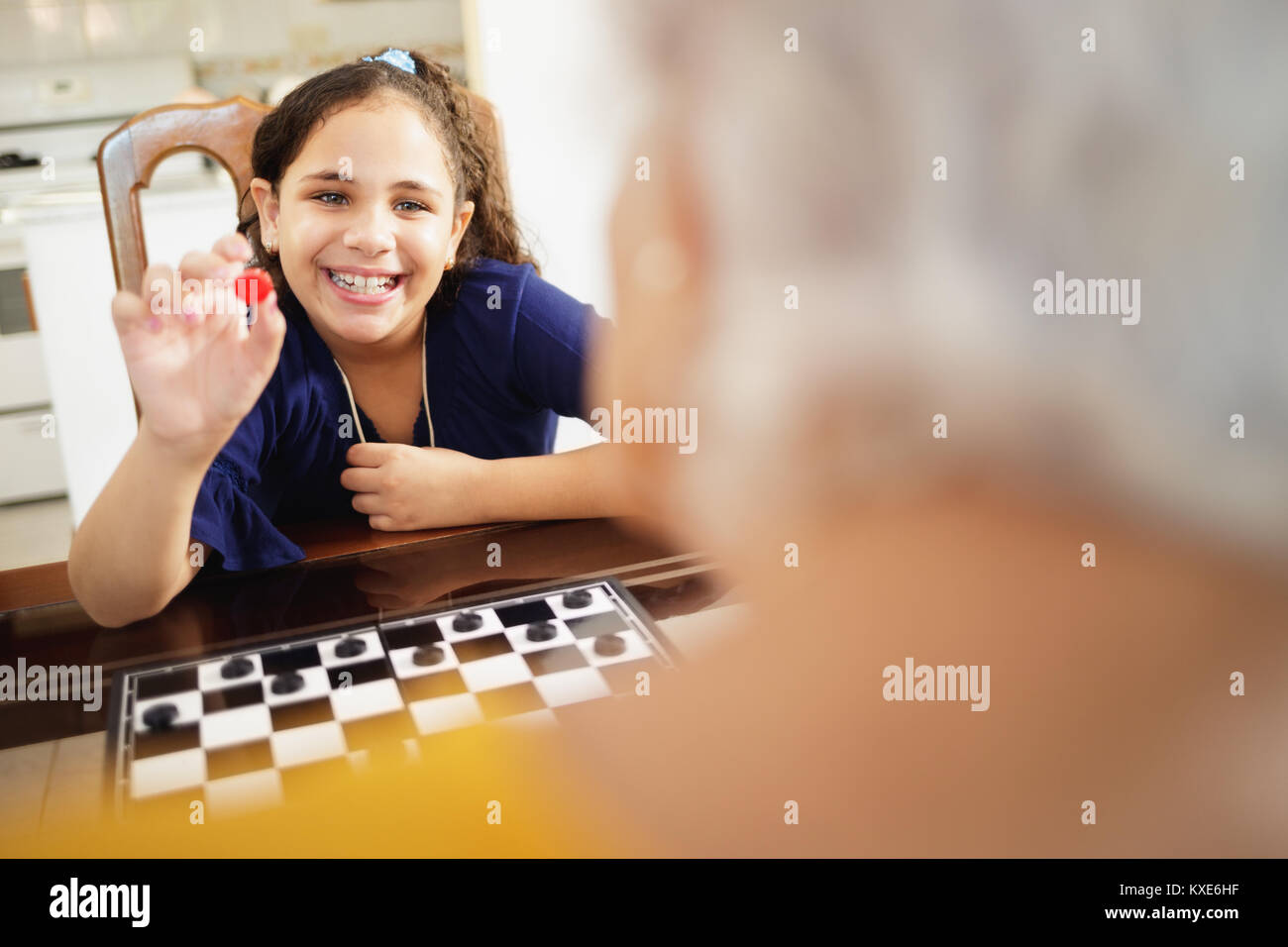 Oma spielen Checkers Board Game mit Enkeltochter zu Hause Stockfoto