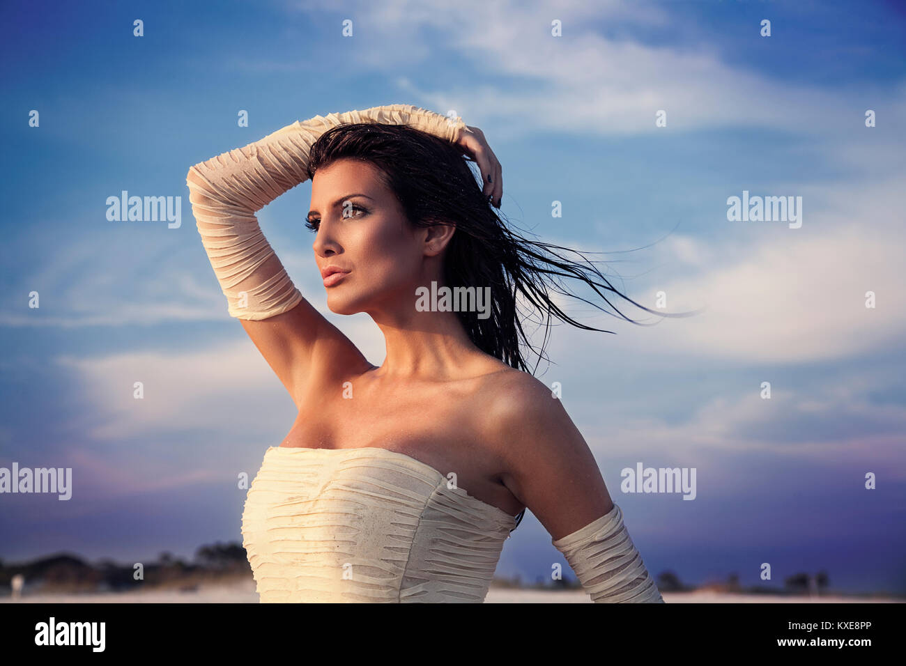 Schöne Frau in weißem Kleid auf dem Strand Stockfoto