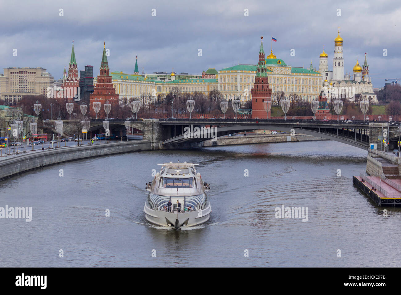Blick auf den Kreml von der patriarchalischen Brücke. Ein tauwetter in der Mitte des Winters. Eine sightseeing Schiff auf nicht gefrorenen Fluss Moskwa im Vordergrund. Stockfoto