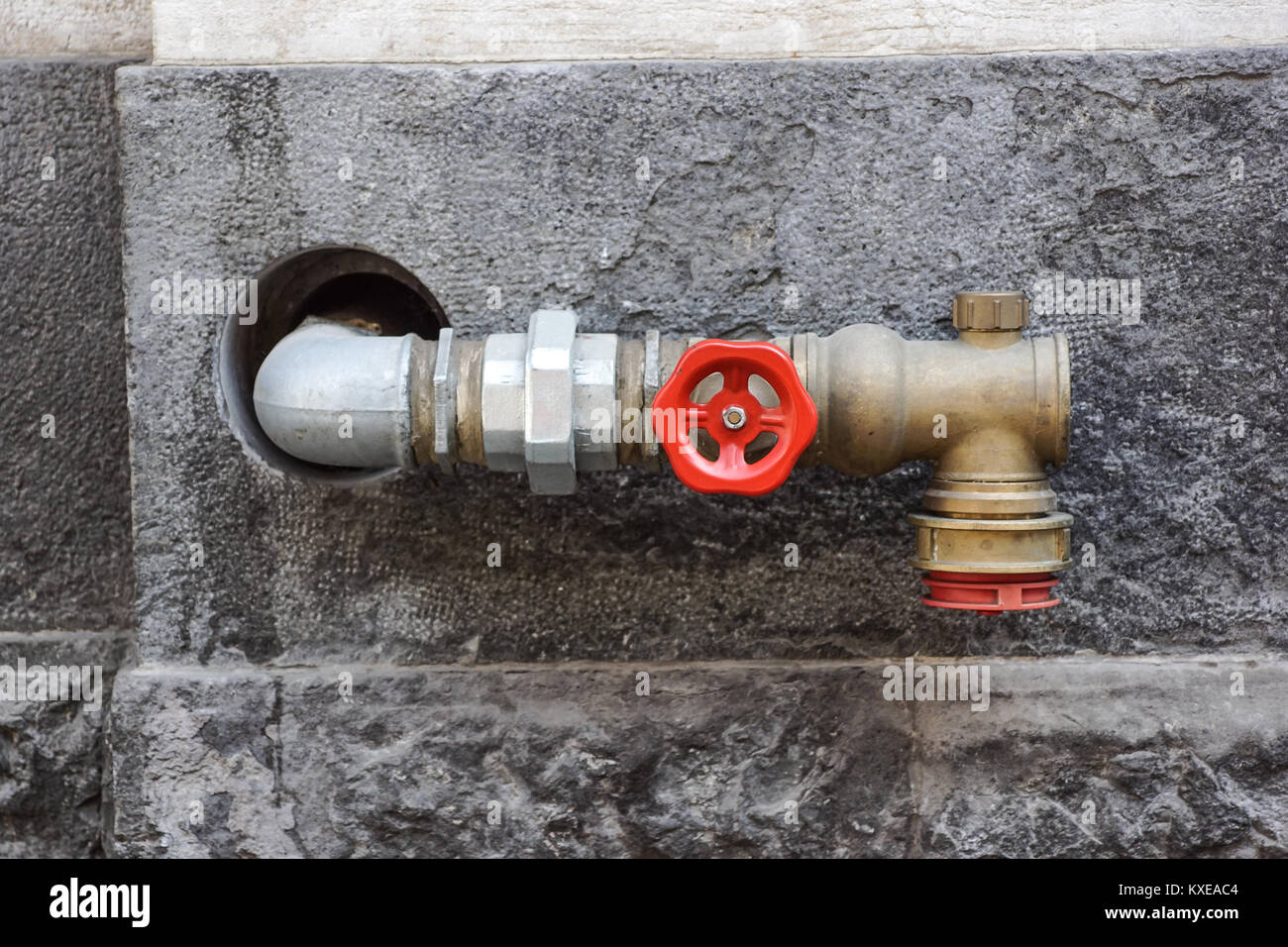 Hydrant mit Schläuchen und Brandschutzanlagen an der Wall löschen Stockfoto