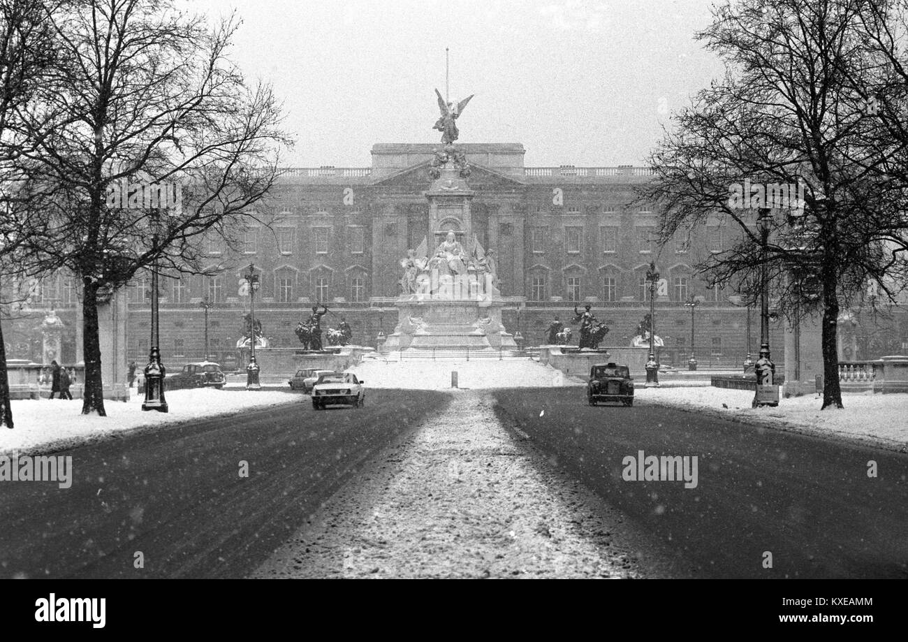 Die normalerweise dunkel rote Fläche der Mall in London, Buckingham Palace (Hintergrund), war im Schnee da Großbritannien weiterhin im eisigen Griff des Winters zu zittern. Stockfoto