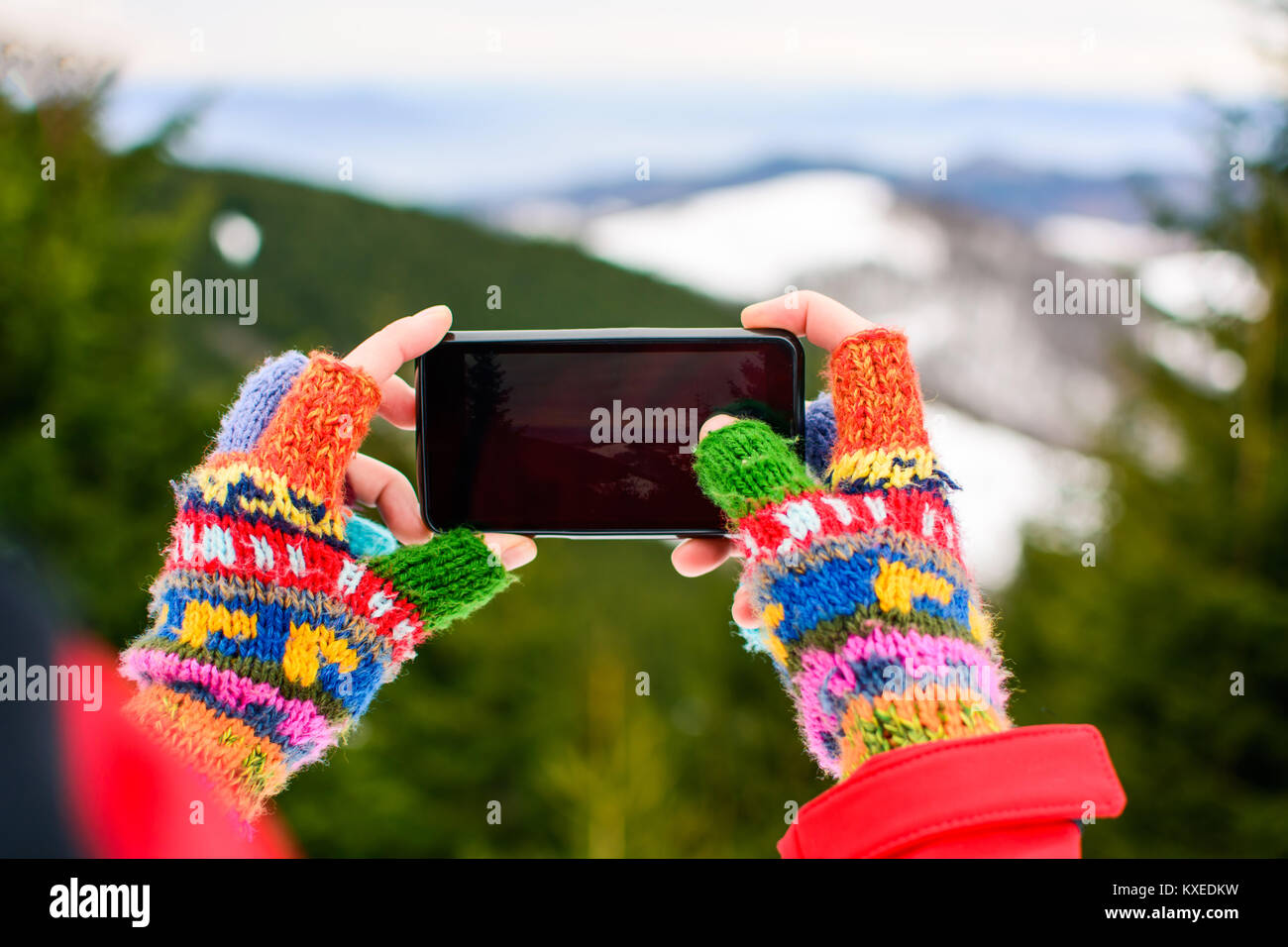 Mädchen nehmen Bild der schönen Winterlandschaft mit einem smart phone Stockfoto