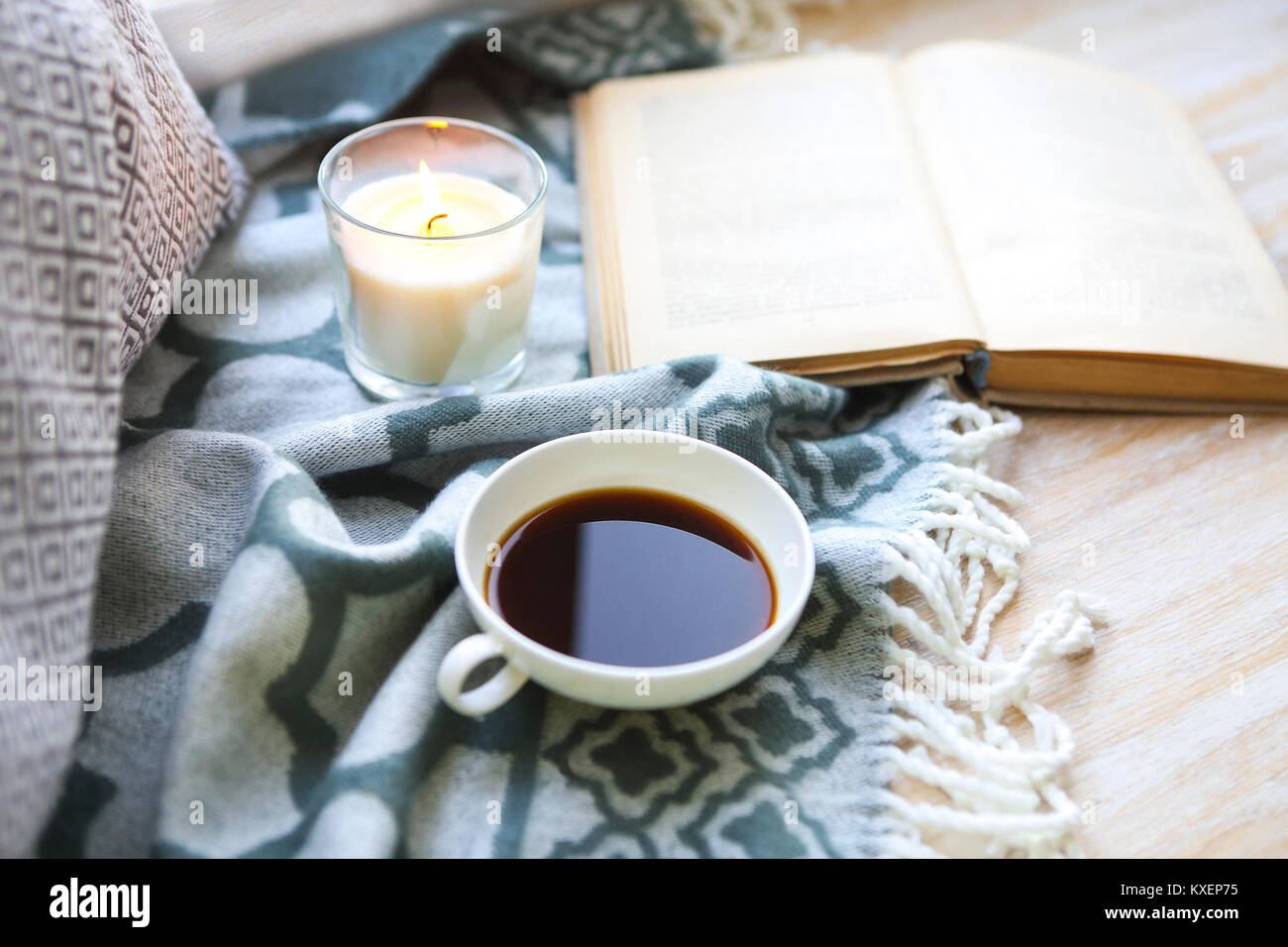 Tasse Kaffee, Kerze und Buch auf dem Holzboden Stockfoto