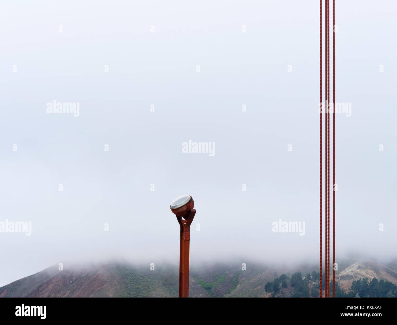 Stahl Kabel und ein Schlaglicht auf die Golden Gate Bridge in San Francisco, Kalifornien (USA), vor den Hügeln von Sausalito, in der mis Verschwinden Stockfoto