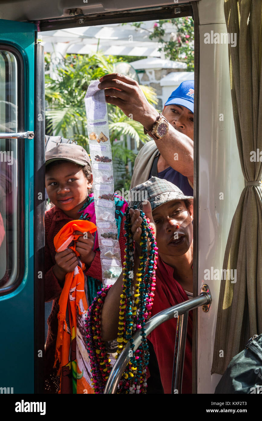 Straßenhändler versuchen, Souvenirs, die von der Tür eines touristischen Bus verkaufen. Madagaskar, Afrika. Stockfoto