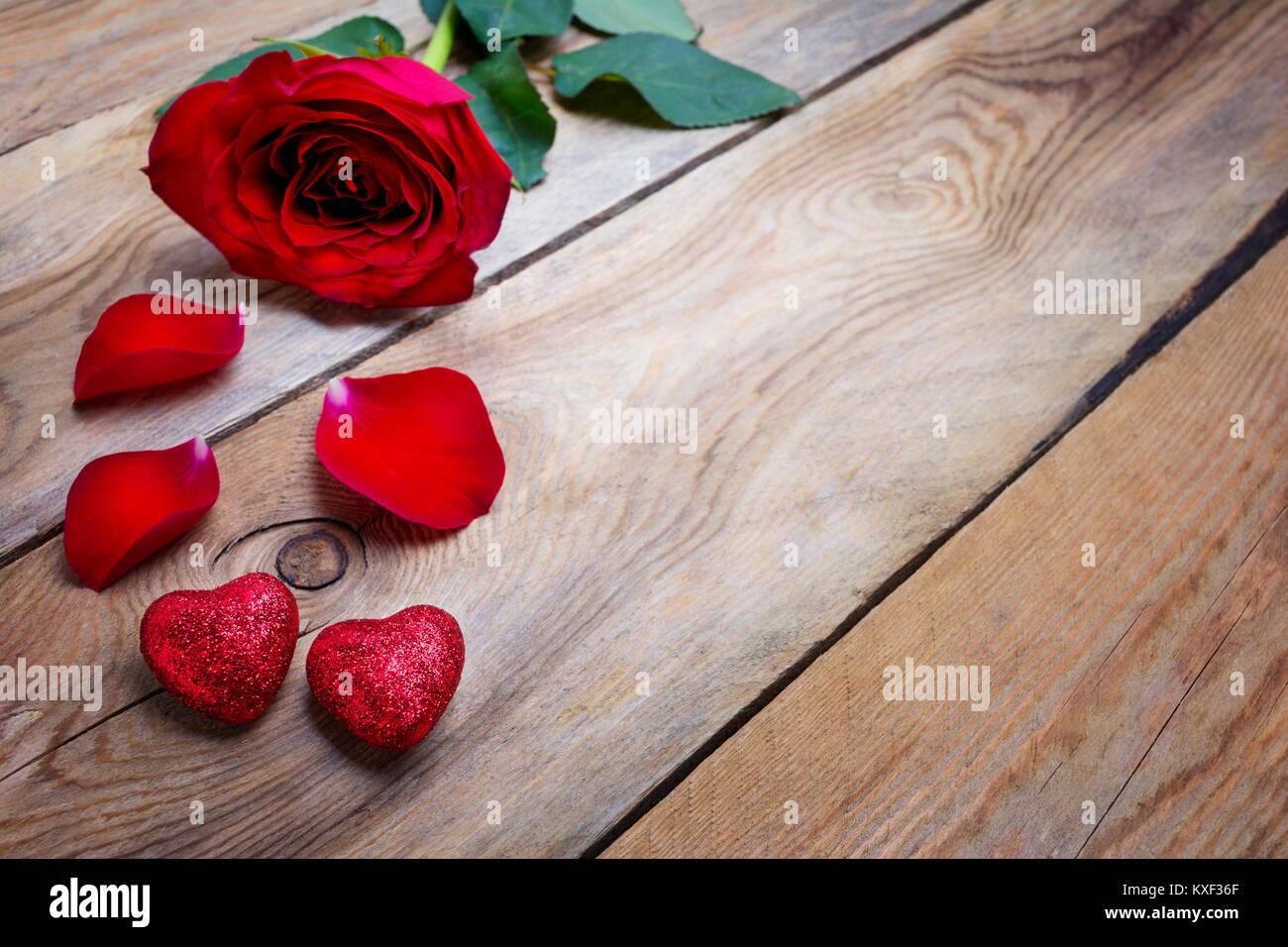 Deep red rose und rote Glitter Herz auf die rustikale Holz- Hintergrund. Valentinstag Grusskarten, kopieren. Stockfoto