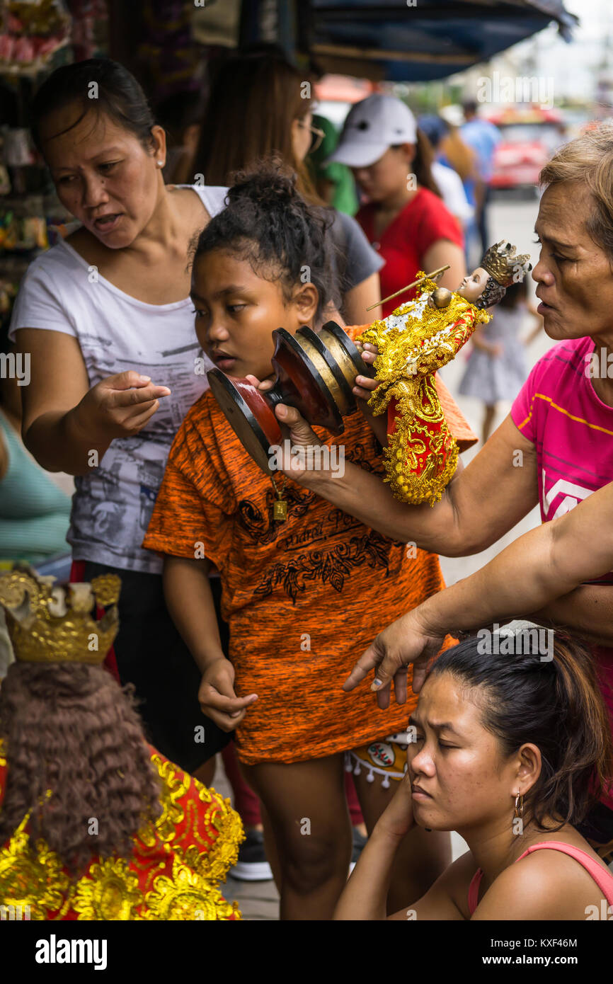 Frau mit einem Santo Nino Figur im Aufbau der Sinulog Fest, Cebu City Stockfoto