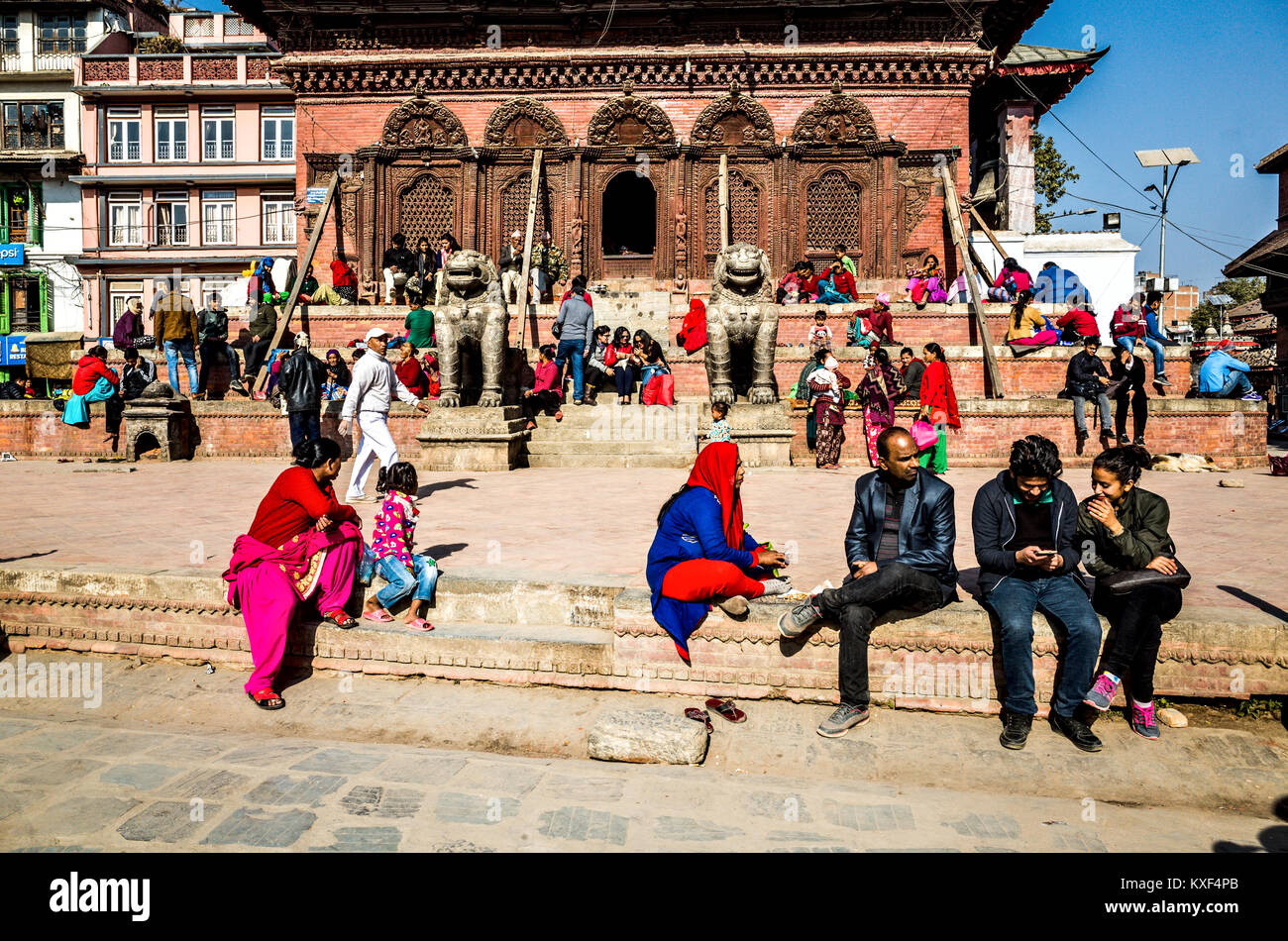 Einige gemütliche Nepalesen Aalen in der Wintersonne, Kathmandu Durbar Square, Nepal Stockfoto