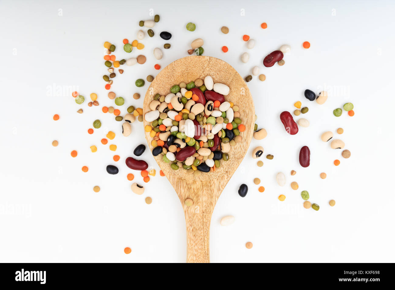 Gemischte Hülsenfrüchte in einem Kochlöffel auf weißem Hintergrund Stockfoto