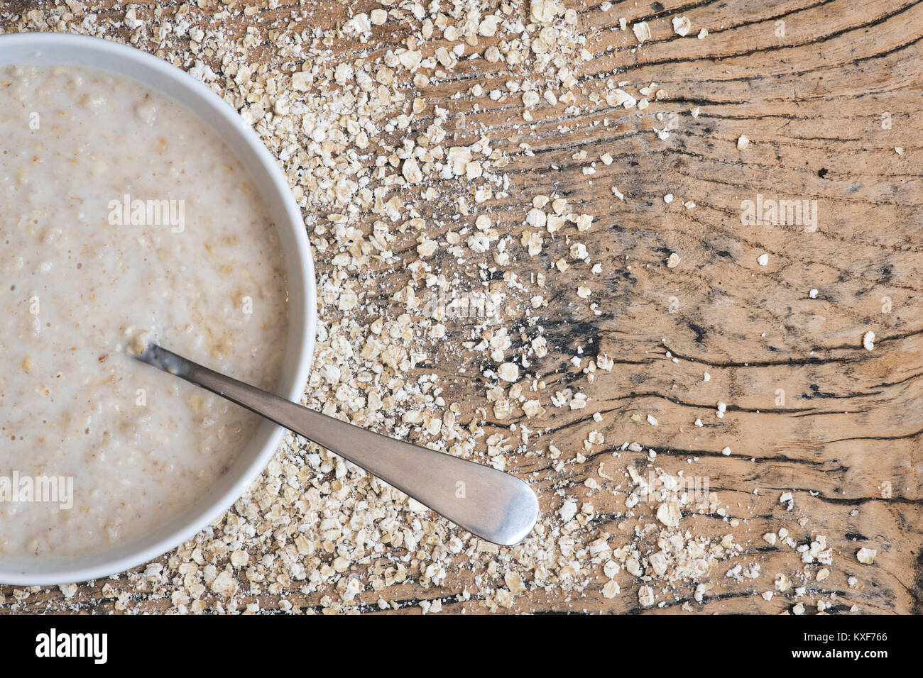 Gekochter brei Hafer in eine Schüssel mit Löffel auf einer hölzernen Hintergrund Stockfoto