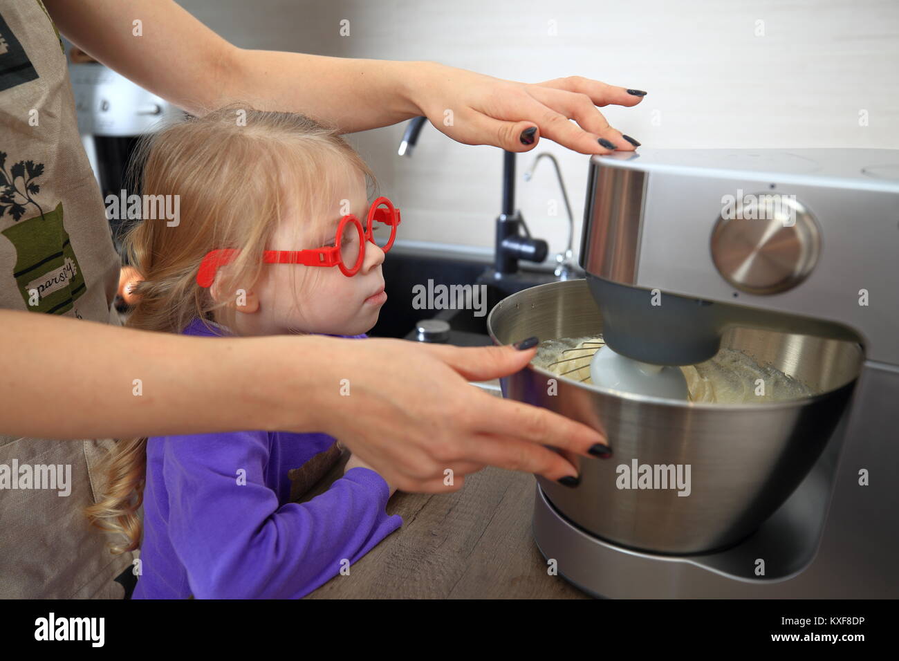 Mutter lehrt Tochter Torte zu kochen. Kochen mit Kind. Stockfoto