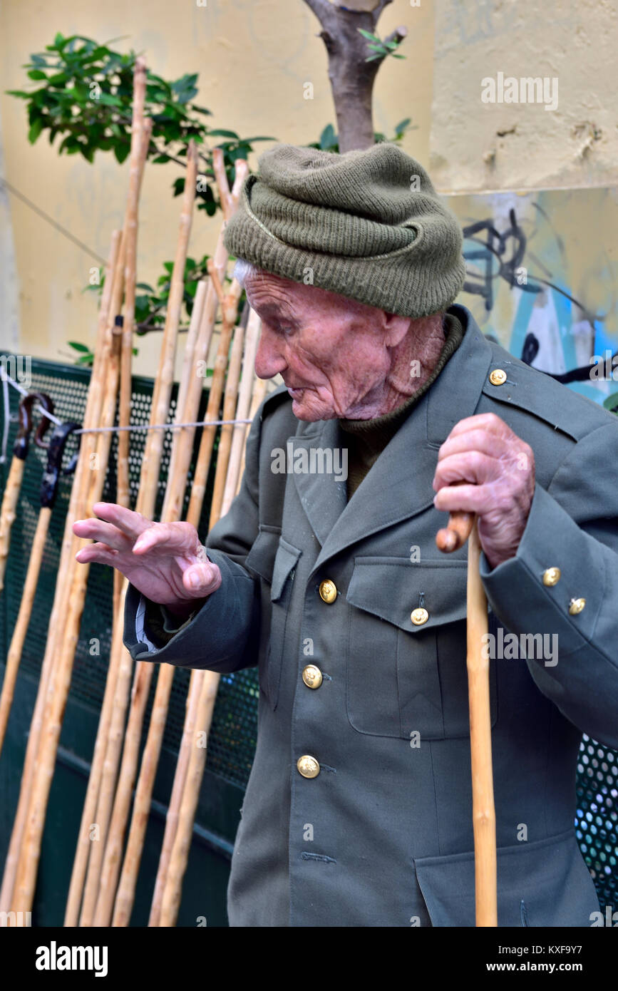 Ältere Mann mit oberen Stock. Er macht und verkauft Walking Stöcke in den lokalen Markt, Athen, Griechenland Stockfoto