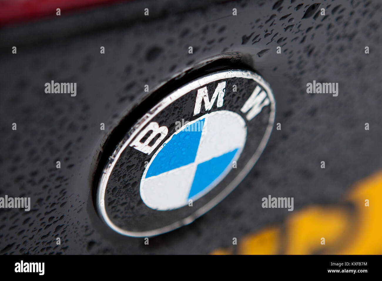 BMW Abzeichen Nahaufnahme Detail eines Schwarzen F83 2016 BMW M4 Cabrio Auto mit Wassertropfen bilden von Regen Stockfoto