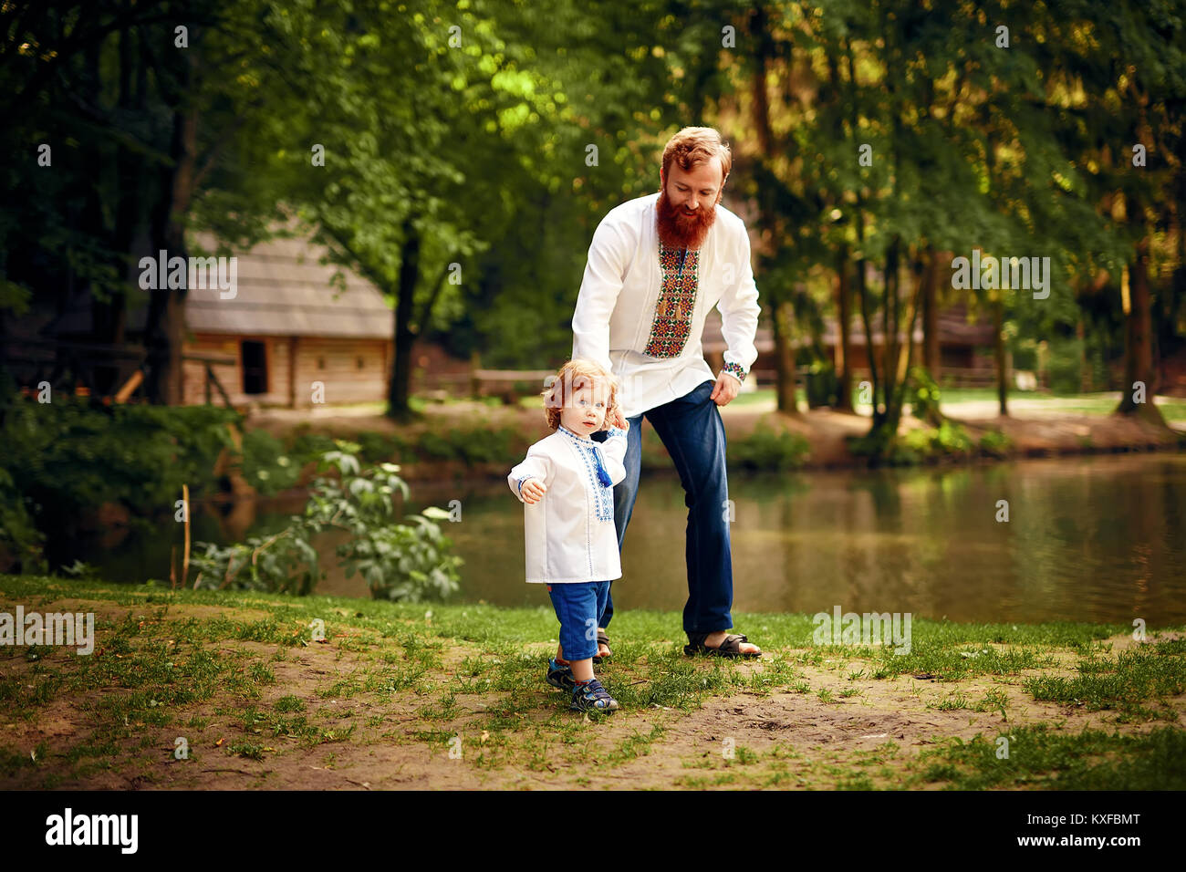 Rot - Heared Vater und rot-Heared Sohn Spaß haben in einem Park in einer traditionellen weißen Hemden mit Ornament Stockfoto