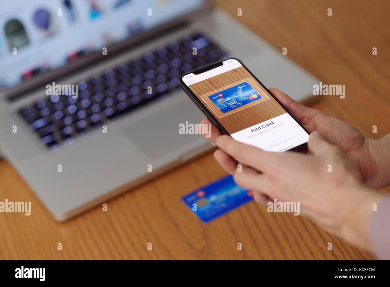 Frau mit iPhone X in ihrer Hand scannen eine Kreditkarte mit Apple, Apple  Wallet elektronische Zahlung app Stockfotografie - Alamy