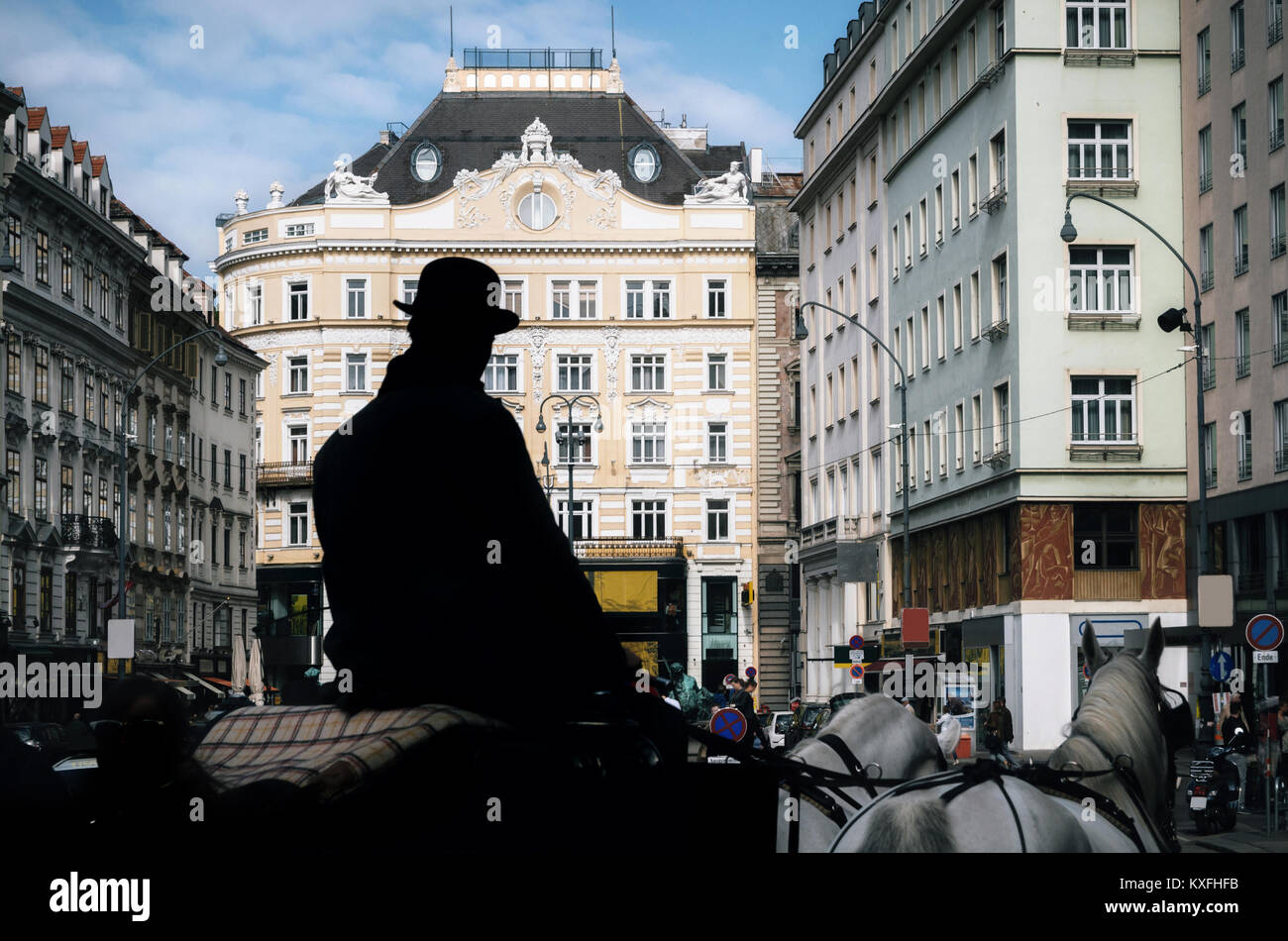 Pferdekutsche Fiaker mit Silhouette der Kutscher als Reiseleiter zu Fuß entlang der alten Straßen von Wien, Österreich Stockfoto