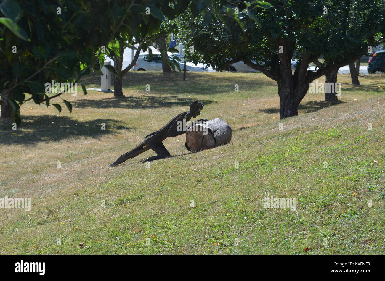 Eine Skulptur des Sisyphus im Altkönigstift Park, Deutschland, zeigt die mythologische Figur, die einen Felsbrocken drückt und die Ausdauer und den Kampf in der griechischen Mythologie symbolisiert. Stockfoto