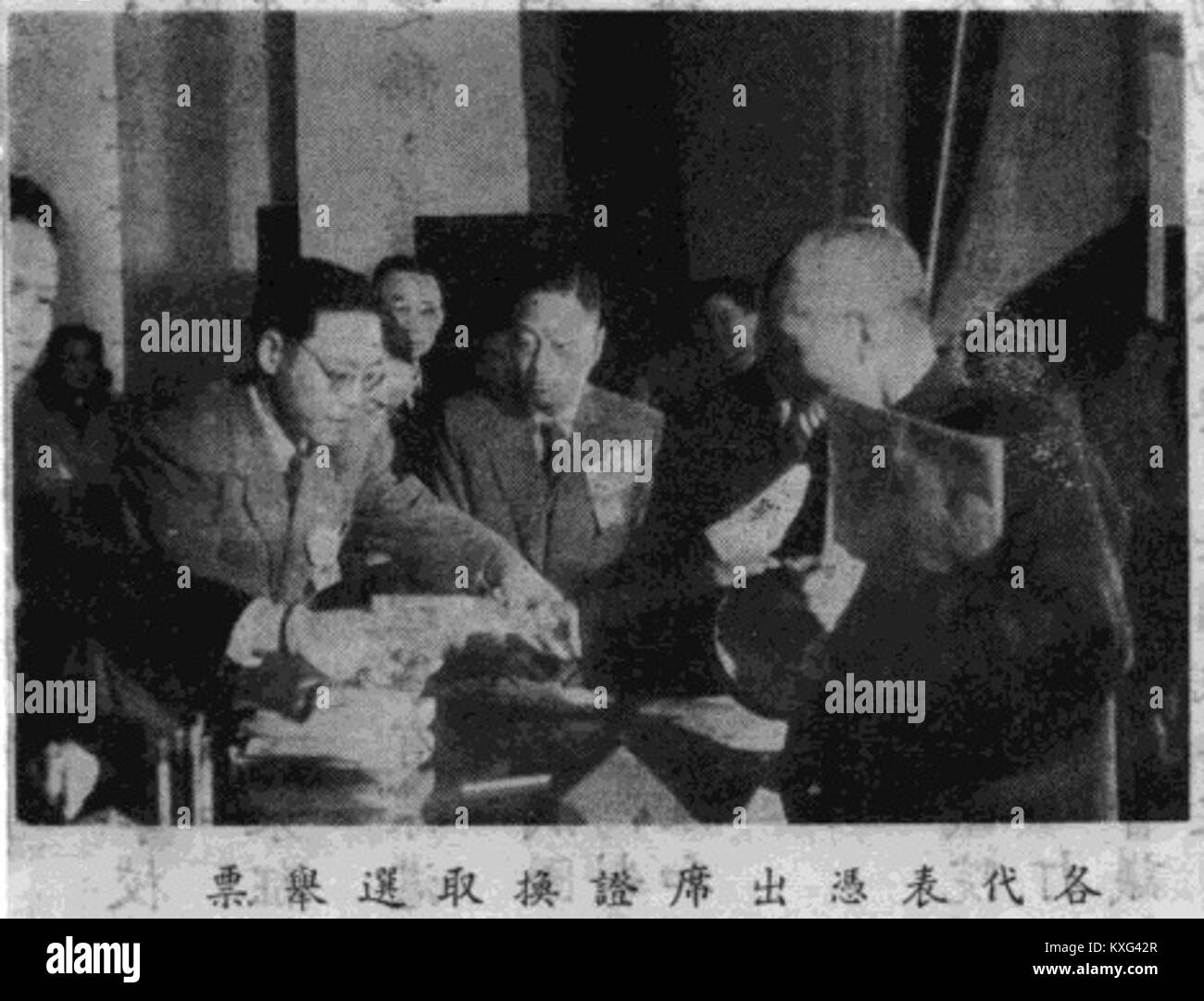 Die Delegierten tauschen Teilnahmebescheinigungen für die Stimmzettel aus, in denen ein Abstimmungsprozess in einer formellen Versammlung oder einem politischen Treffen in China beschrieben wird, wahrscheinlich ab der Mitte des 20. Jahrhunderts. Stockfoto