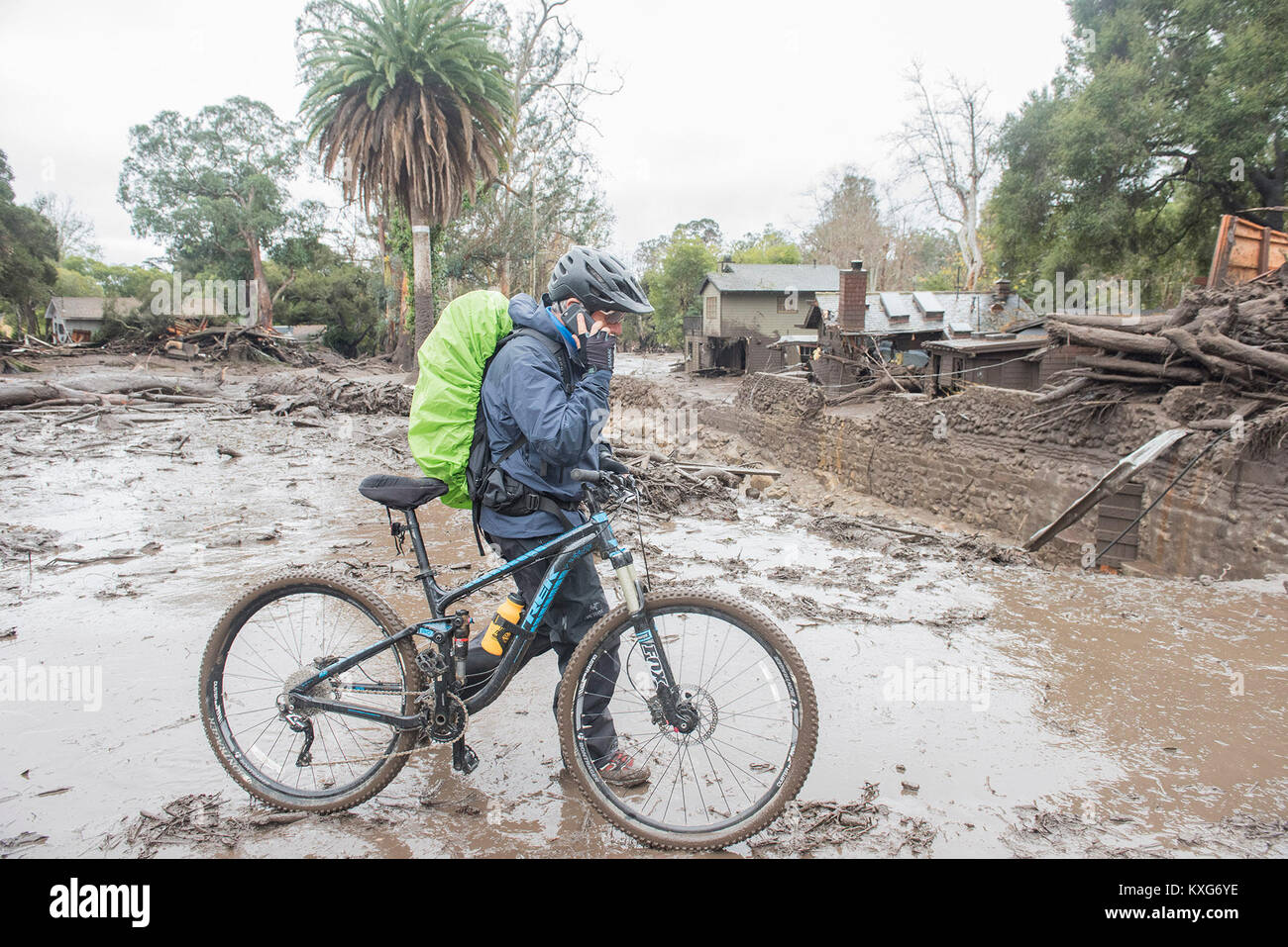 Montecito, Kalifornien, USA. 9 Jan, 2018. CHRIS HASKELL, der Montecito, Kreuze Montecito Creek als geht er auf seinem Fahrrad zu arbeiten. Sturzfluten closed Down East Valley Rd, wo der Bach überquert. Sechs Menschen wurden getötet und mindestens sechs Wohnungen wurden von muren in Santa Barbara County fegten. Credit: Erick Madrid/ZUMA Draht/Alamy leben Nachrichten Stockfoto