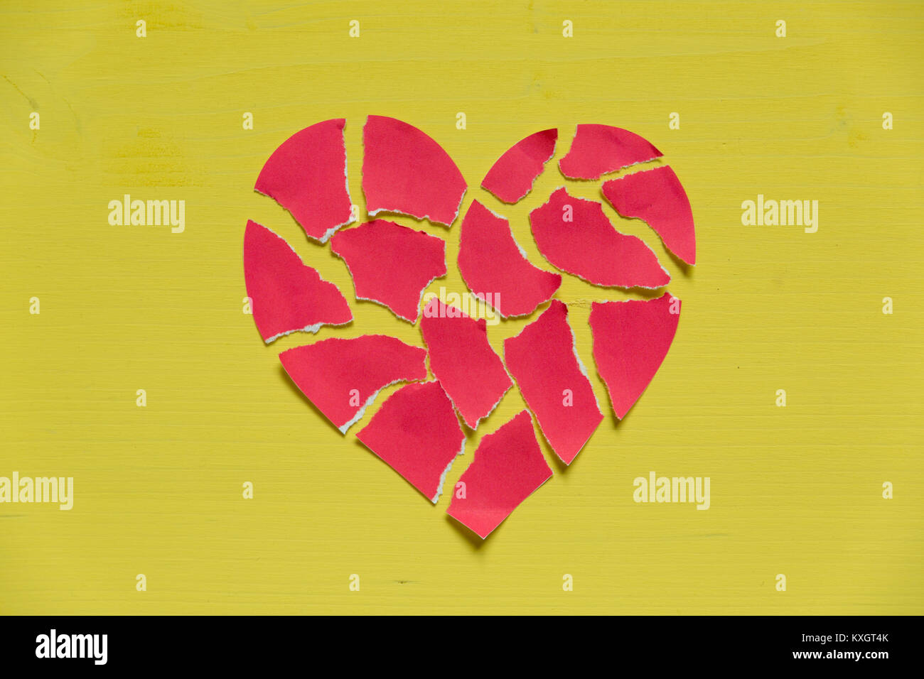 Zerkleinert Papier Herz auf gelben Hintergrund. Gebrochenes Herz Konzept Stockfoto