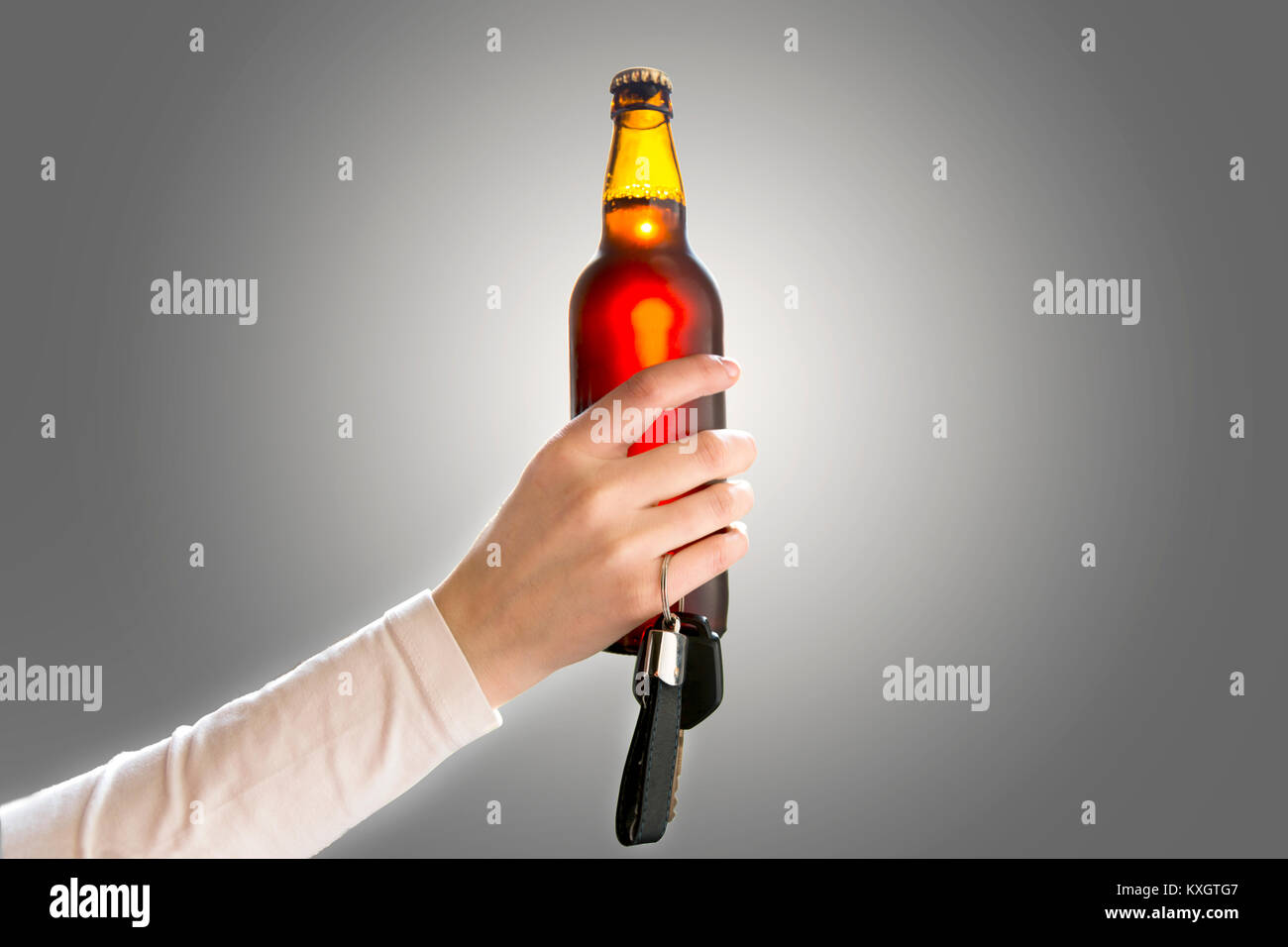 Woman's Hand, die eine Flasche Bier und Autoschlüssel. Nicht trinken und Antriebskonzept Stockfoto