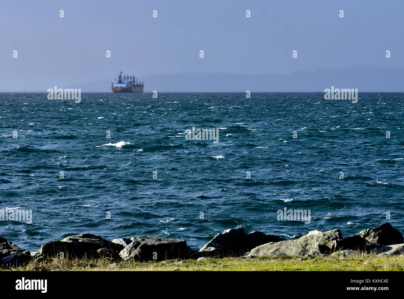 Ein Frachtschiff Fahrten vor Anker aus Victoria, B.C., Kanada bei einem Sturm in Juan de Fuca Strait. Stockfoto