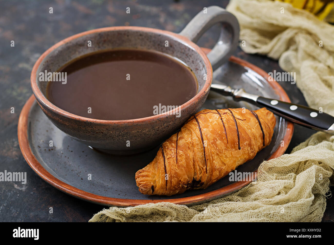 Tasse duftenden Kaffee und ein Croissant. Frühstück Stockfoto