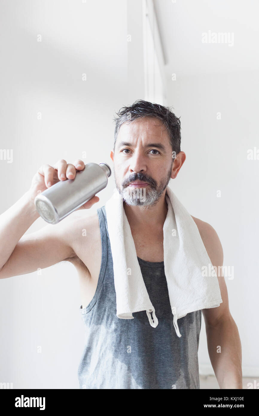 Porträt eines reifen Mannes, der eine Wasserflasche hält Stockfoto