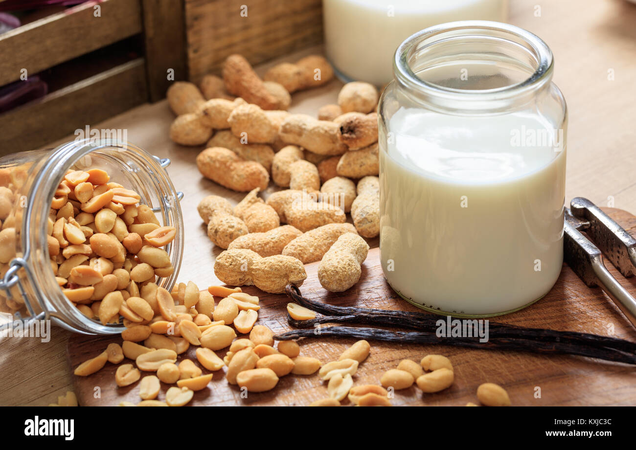 Vegan Milch aus Erdnüssen auf einer hölzernen Oberfläche Stockfoto