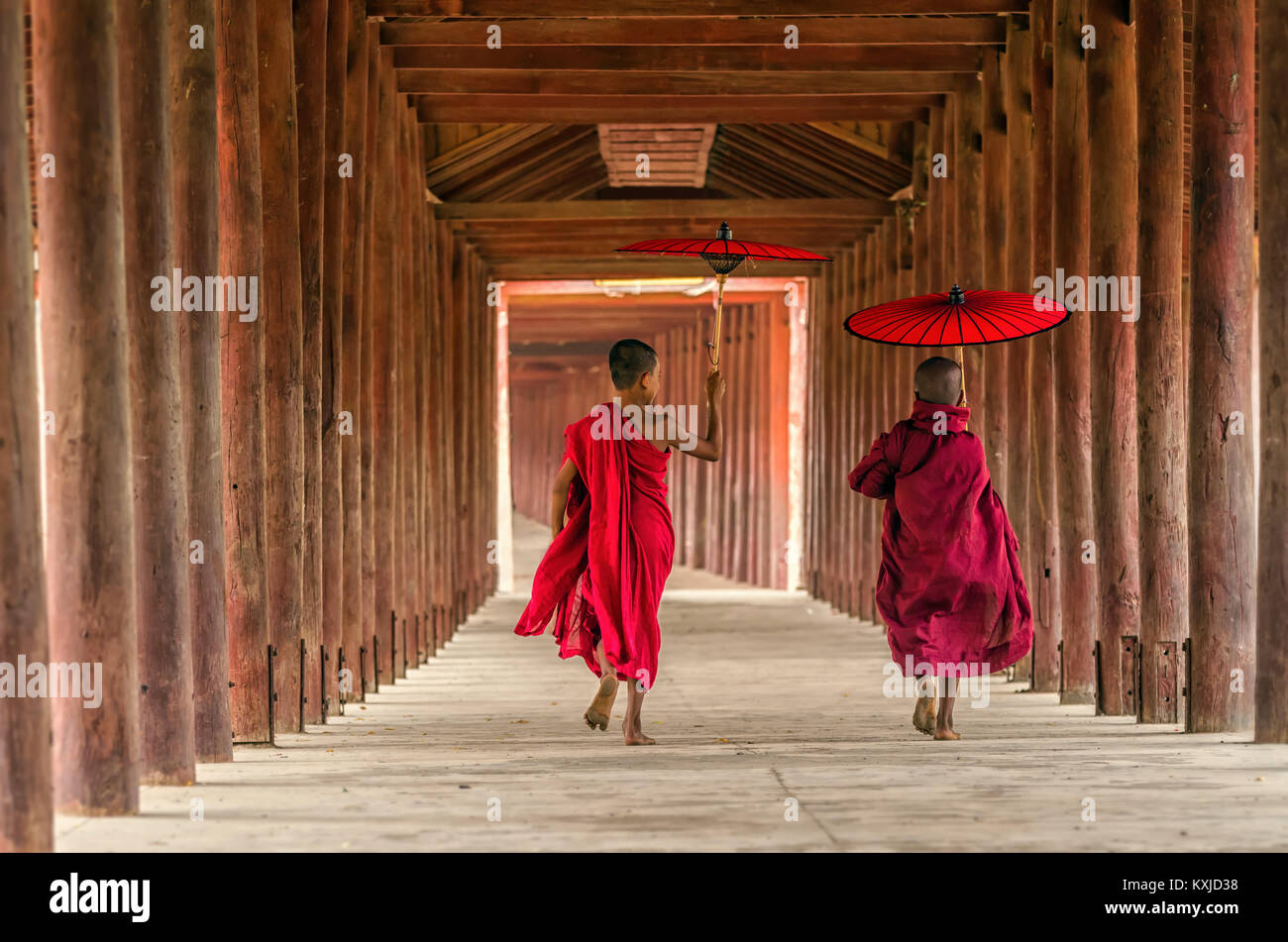 Rückseite der zwei junge Mönch halten der traditionellen Regenschirm auf dem Mya Thein Tan Pagode in Bagan, Mandalay, Myanmar buddhistische Anfänger sind zu Fuß in Pa Stockfoto