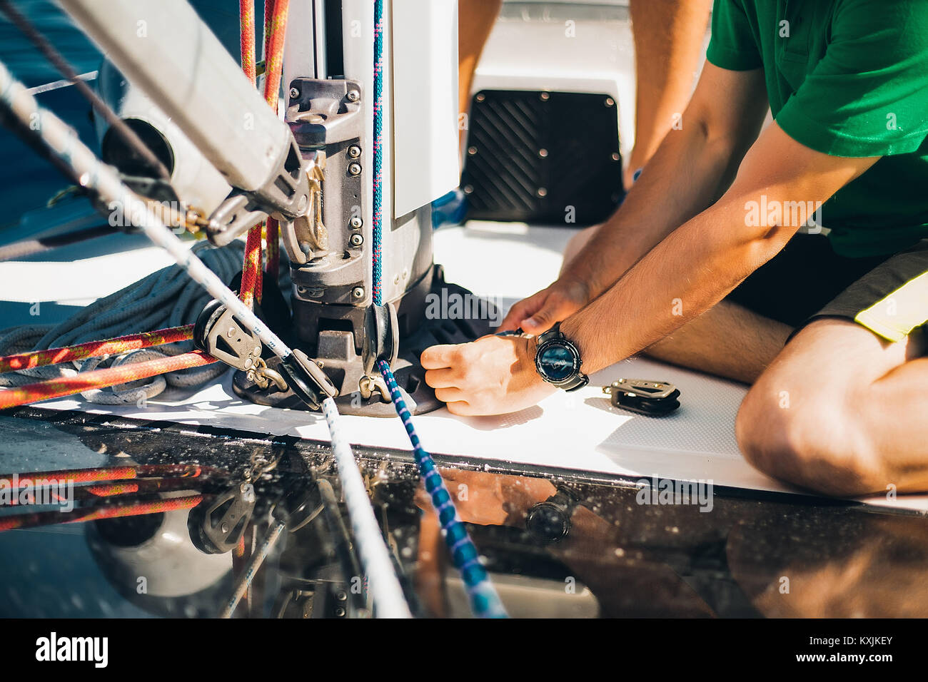 Mann bei der Arbeit an Seilen auf Segelboot Stockfoto