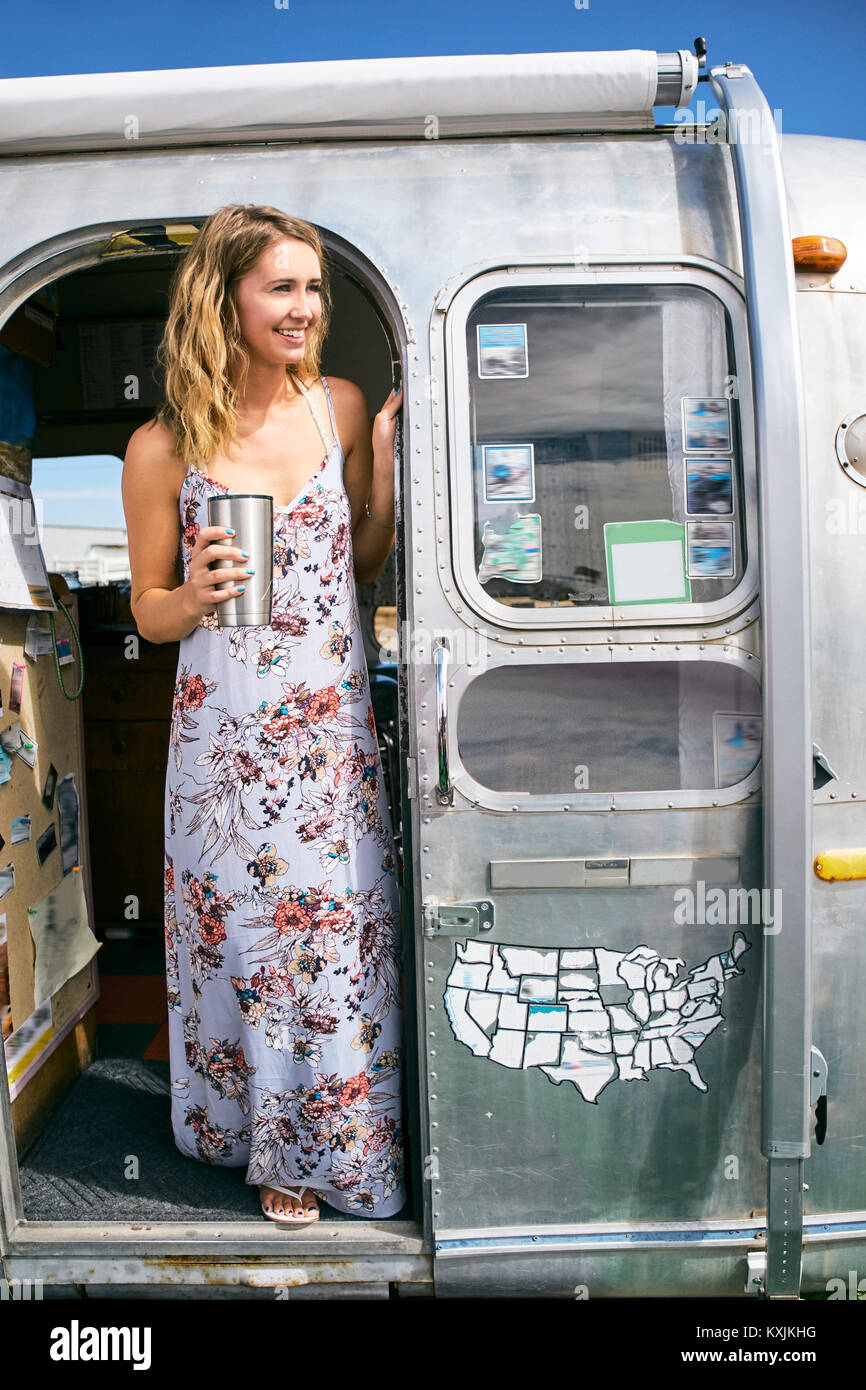 Junge Frau trägt Maxi Kleid von airstream Tür Stockfoto