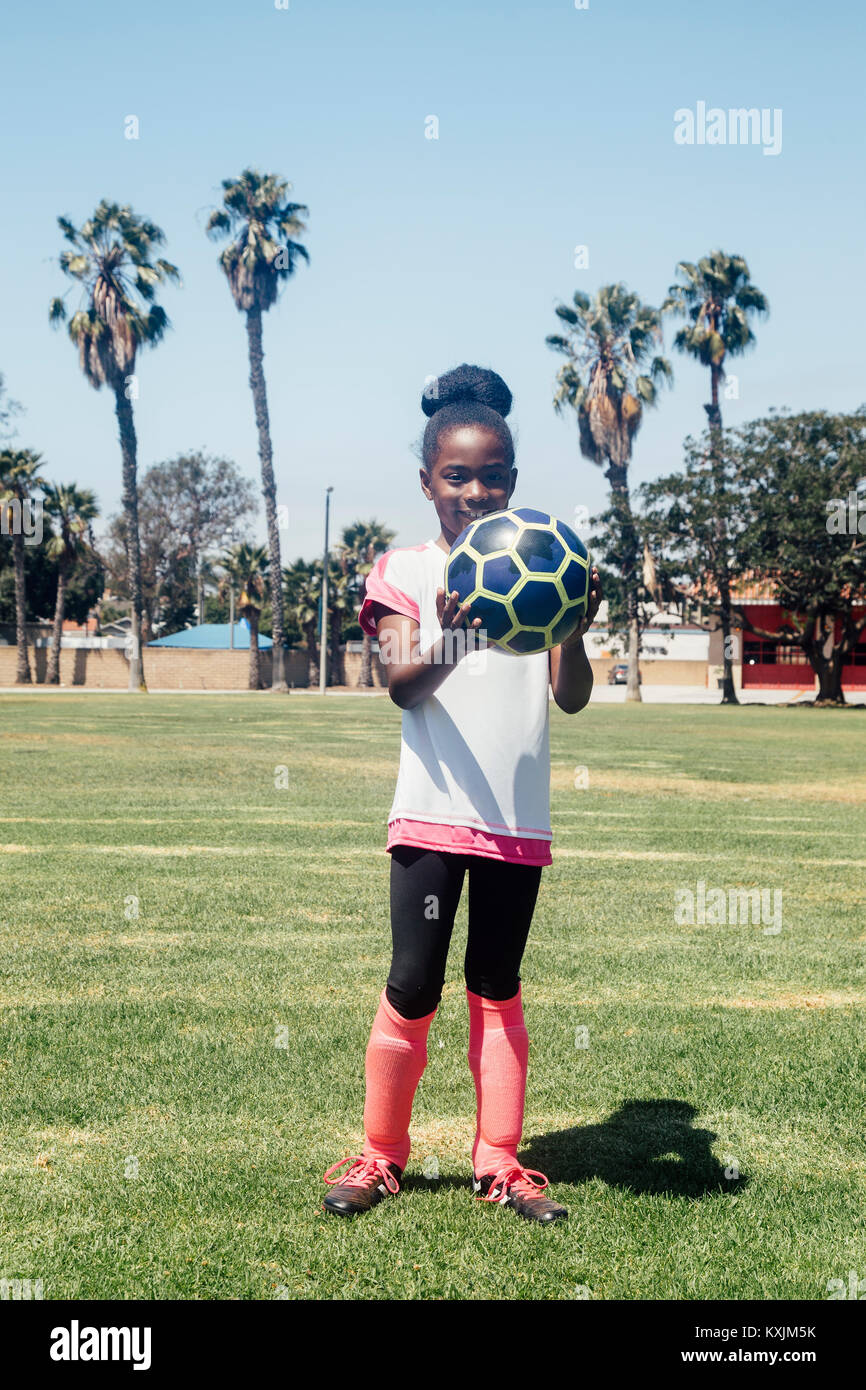 Portrait von Schulmädchen Fussball Spieler mit Fußball auf Schule Sportplatz Stockfoto