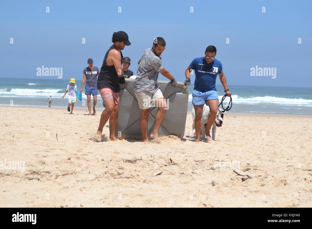 Starke Männer Entfernen großer Kunststoff Wurf vom Strand während einer Beach Clean Up in Portugal Stockfoto