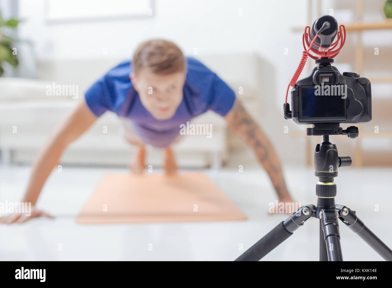 Junge blogger schauen in die Kamera, während Sie liegestütze Stockfoto