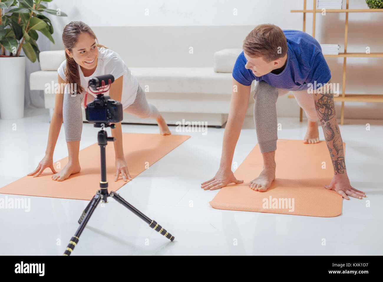 Fröhliche Menschen einander an, die während des Trainings auf ihre Yoga Matten Stockfoto