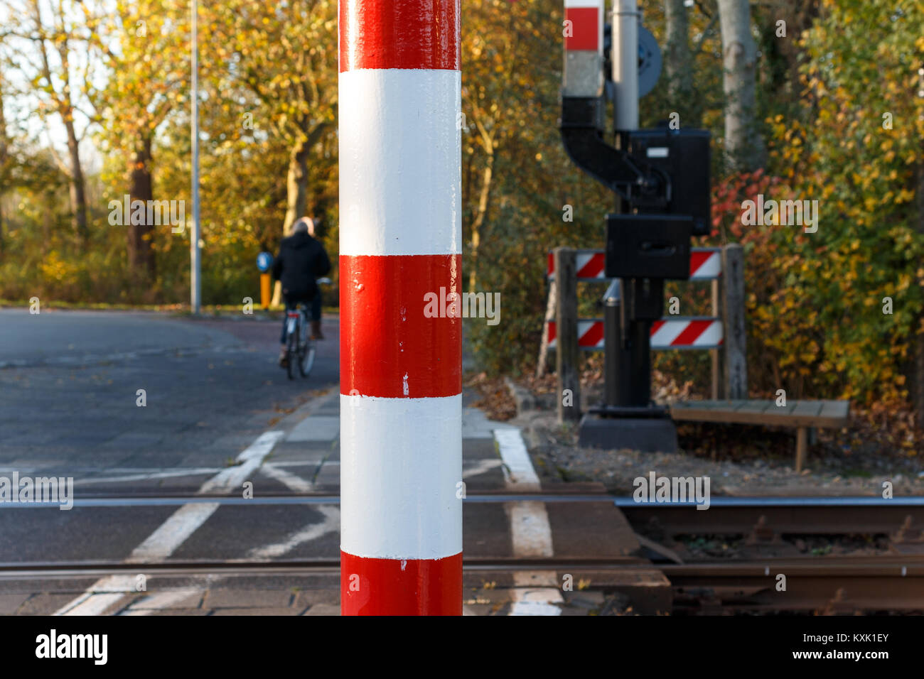 In der Nähe der Pole der Bahnübergang in den Niederlanden mit Mann auf dem Fahrrad im Hintergrund Stockfoto