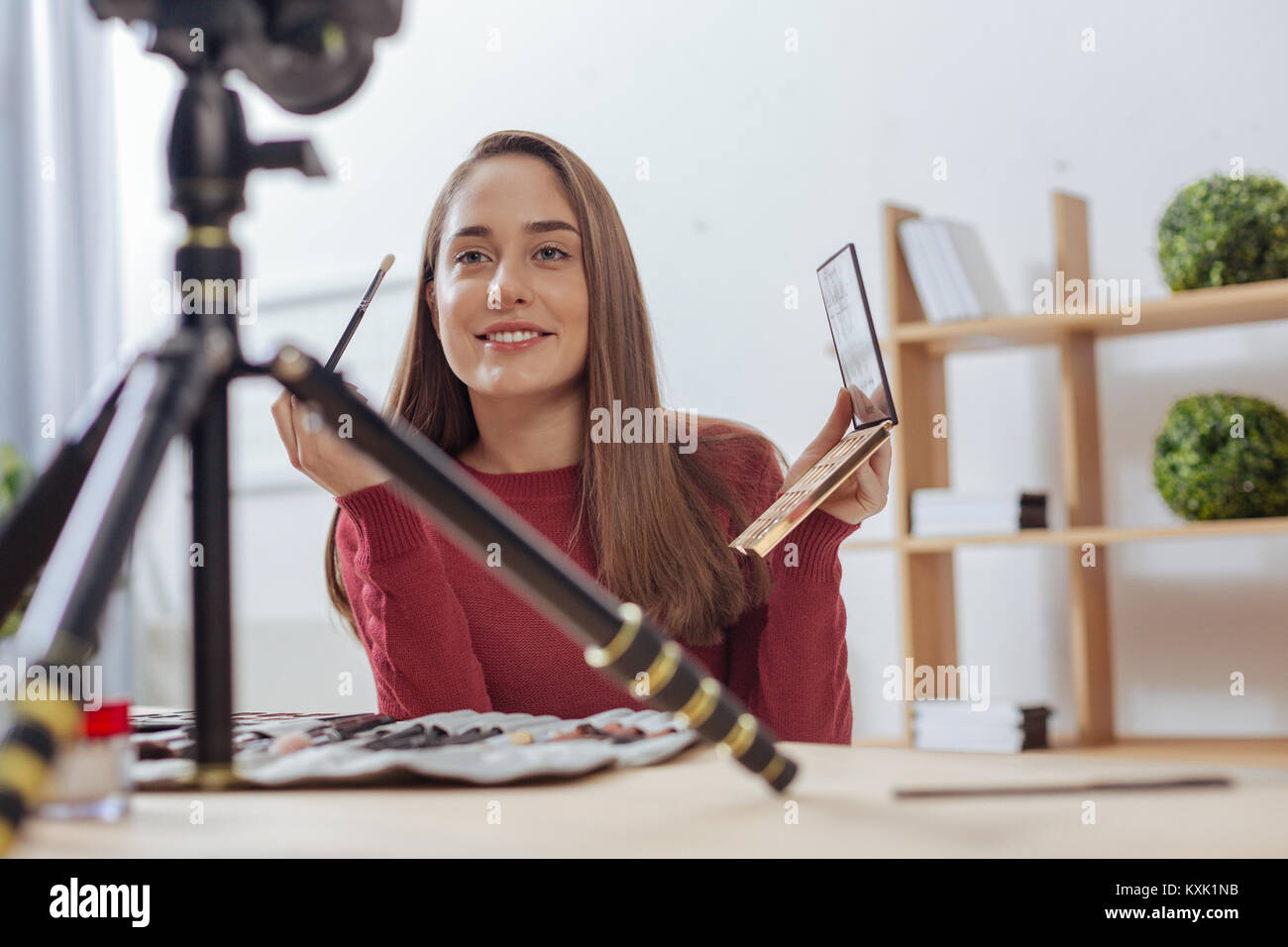 Begeistert schöne Frau lächelnd in die Kamera halten Sie eine Bürste Stockfoto