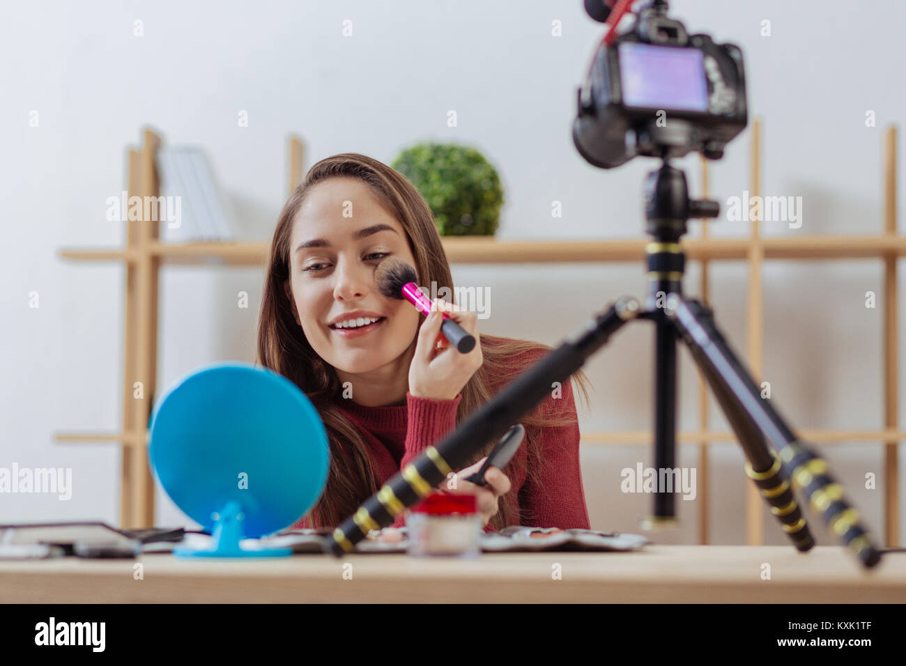 Happy Fashion Blogger setzen auf Gesichtspuder und freundlich lächelnd Stockfoto
