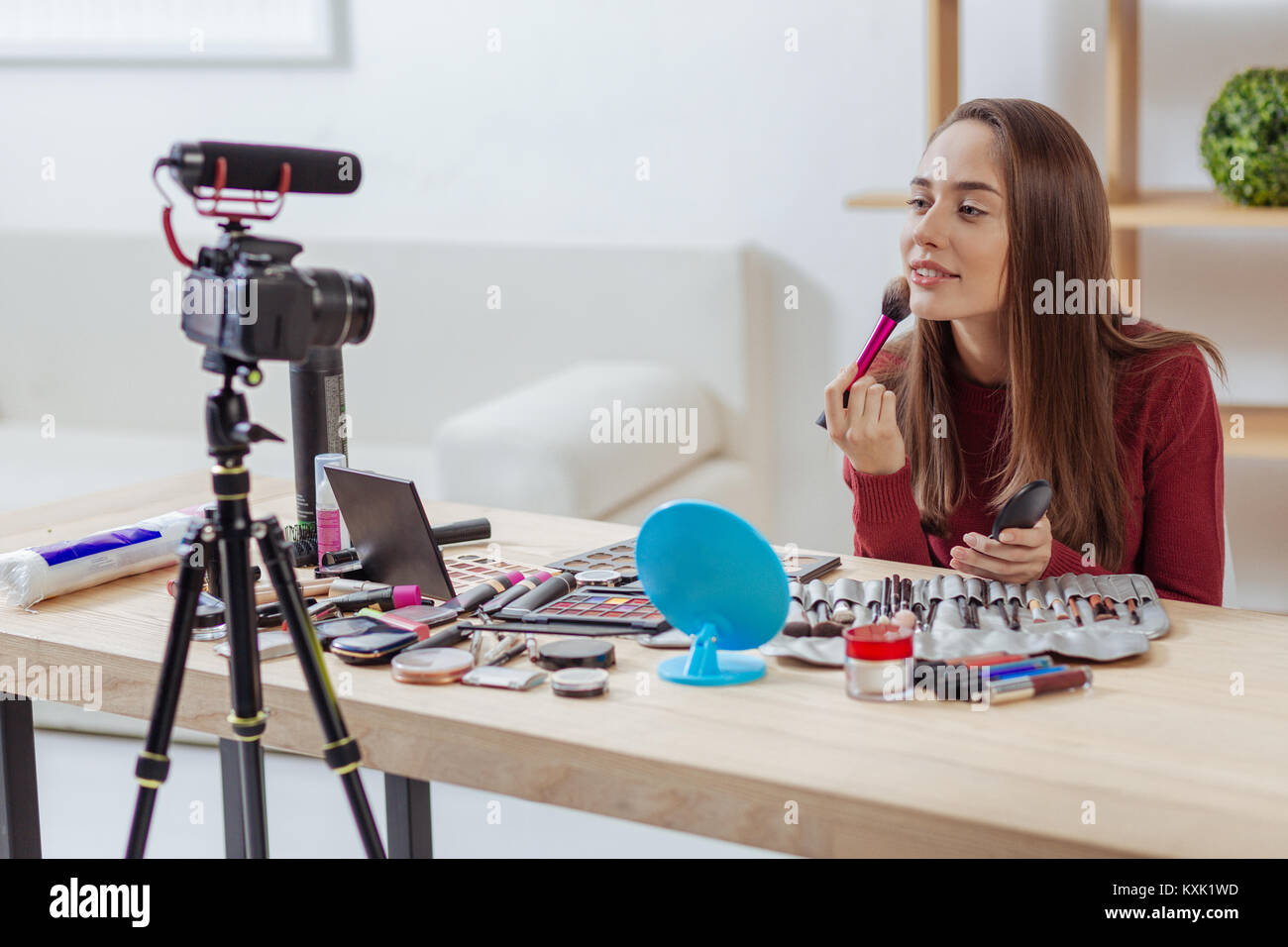 Gerne blogger Testen einer neuen Bürste für Gesichts Puder und Suchen froh Stockfoto