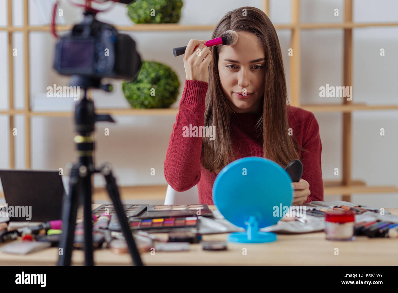Konzentriert Blogger testen erstaunliche Gesichtspuder und suchen ernsthafte Stockfoto