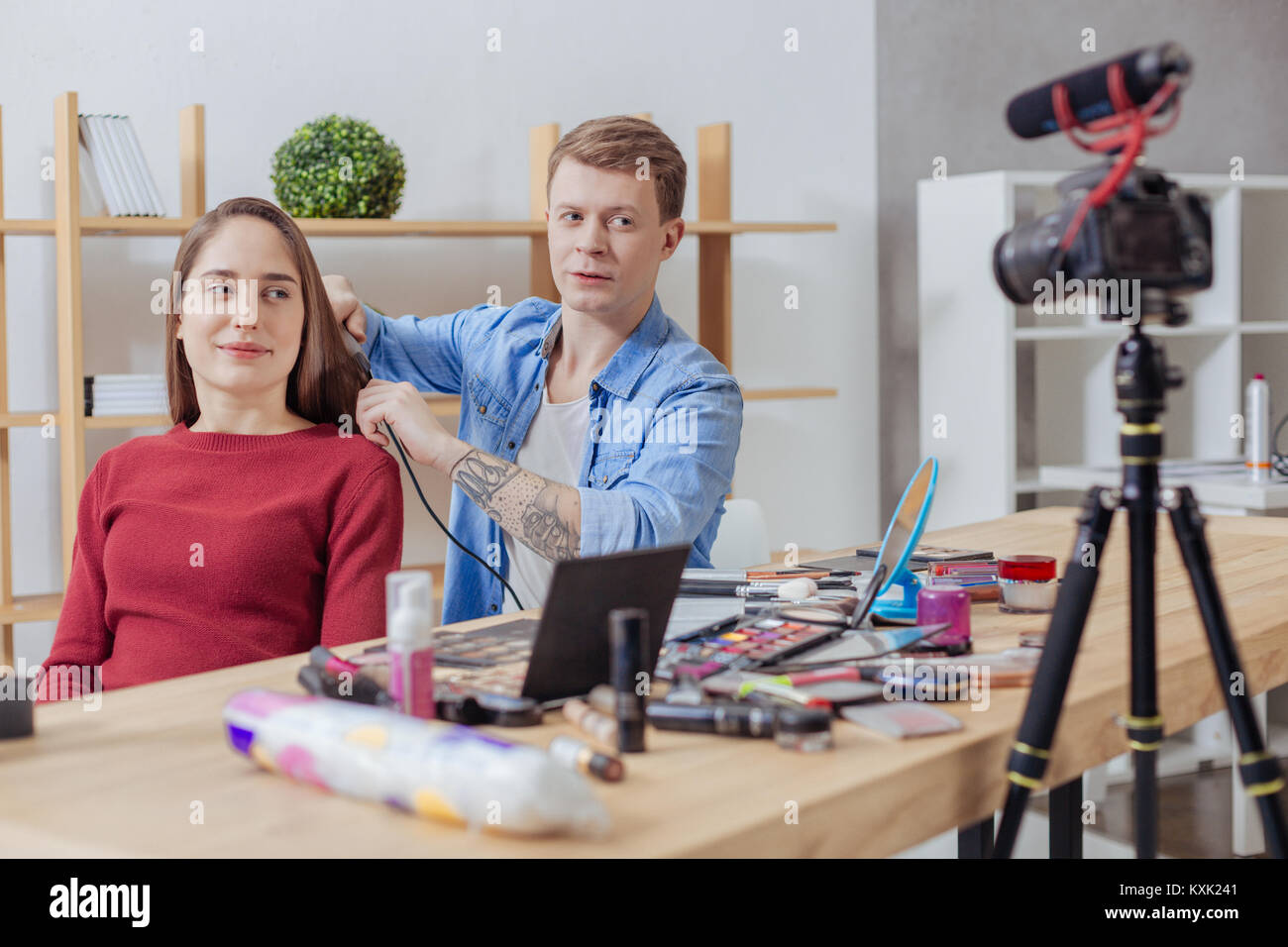 Fröhliche Frau lächelnd in die Kamera, während Ihr Friseur arbeiten Stockfoto
