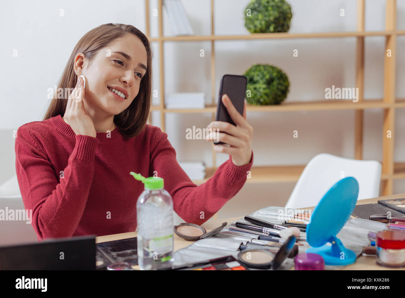 Positive Frau lehnte ihren Kopf, während das Make-up entfernen Stockfoto