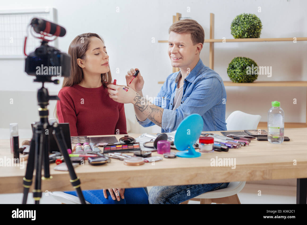 Qualifizierte Fashion Blogger sitzt mit seinem Freund und testen alle Lippenstifte Stockfoto