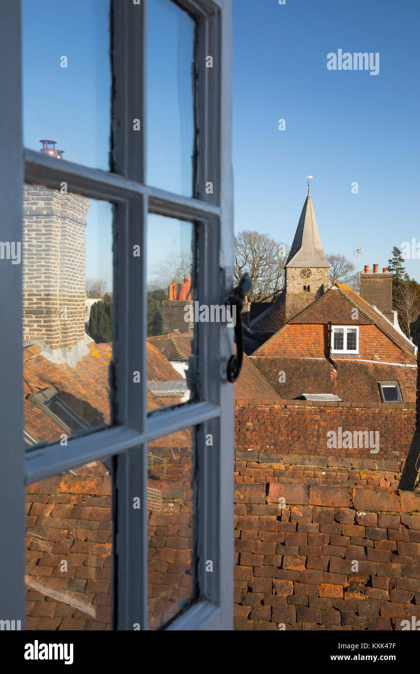 Blick durch offene Fenster über Cottage Roof Tops nach St. Bartholomä, Burwash, East Sussex, England, Vereinigtes Königreich, Europa Stockfoto